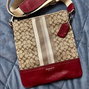 Red and tan Coach crossbody bag with adjustable strap. Fabric and leather bag.